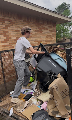 LB, owner of LB's Junk Removal, standing in front of a cleared junk pile